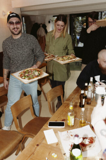 Marketing agency account and project managers serving pizzas at a restaurant