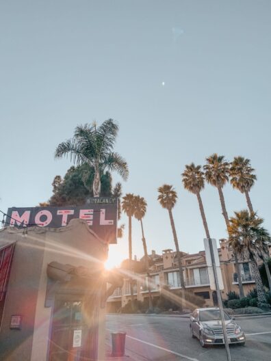A sign of a motel in Santa Cruz California with palm trees in the background