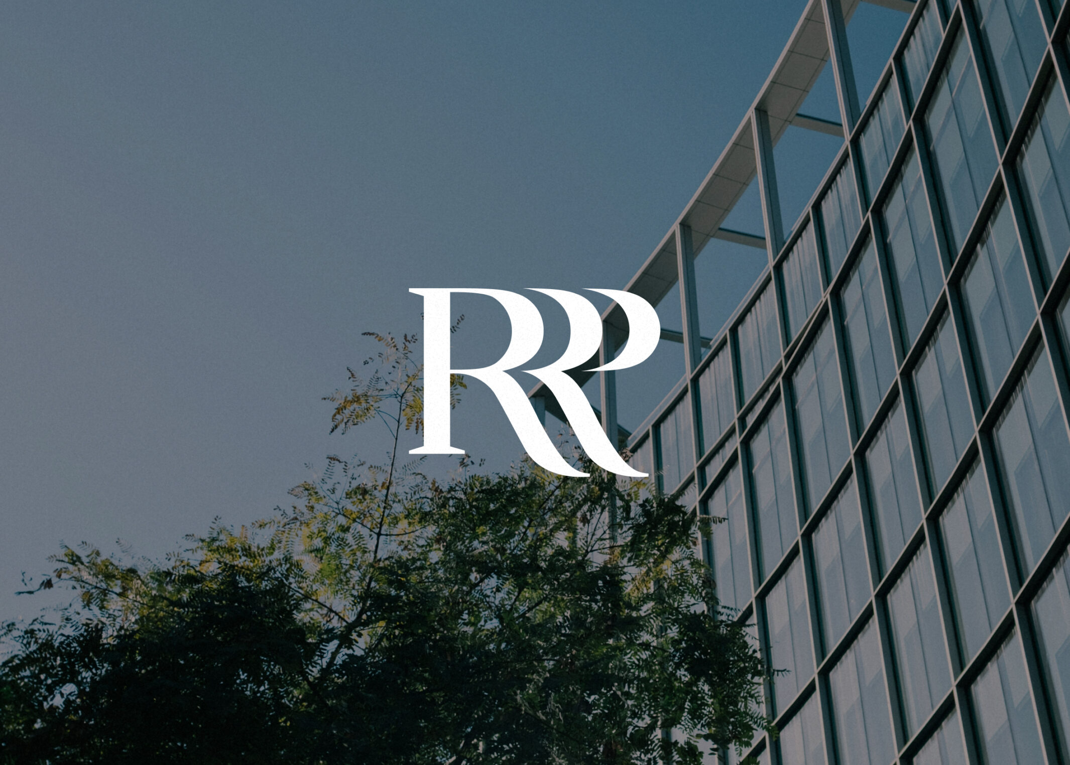 Rising Realty Partners logo over a modern office building.