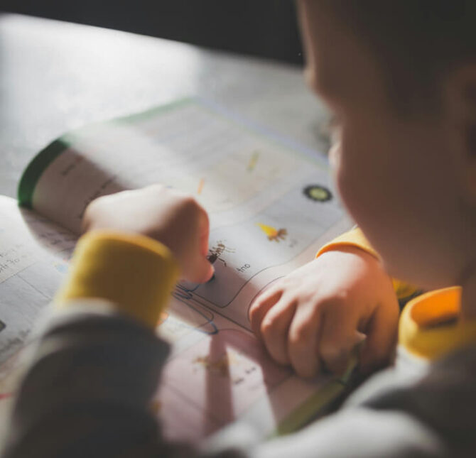 Child completing a learning activity in a workbook.